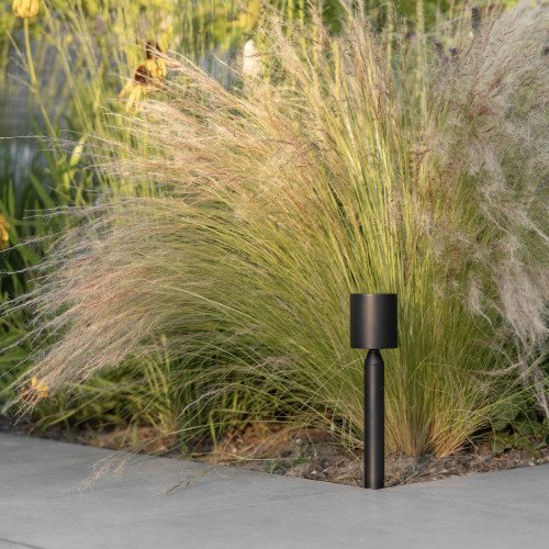 Lampe de jardin Issy noire small près des graminées ornementales avec lumière dirigée vers le bas